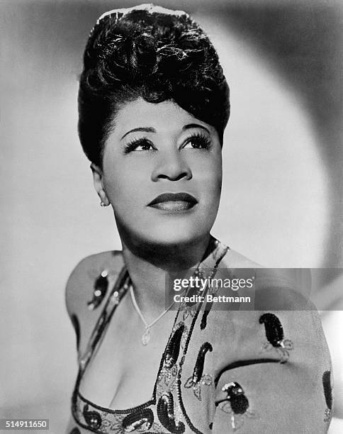 Portrait of American blues singer, Ella Fitzgerald. She is shown posing in a studio in a sequined dress. Undated photo circa 1940s.