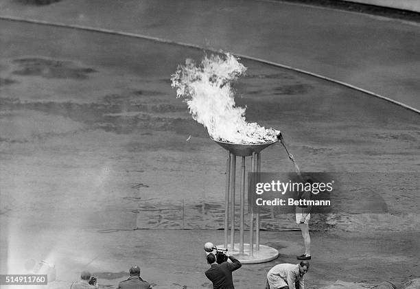 Helsinki, Finland- Finland's Paavo Nurmi lights the 1952 Olympic fire with the tourch he carried into the Helsinki Stadium, July 19, to officially...