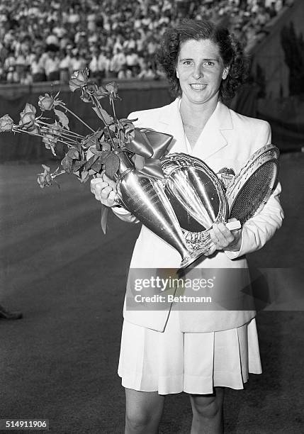 Forest Hills, NY- Mrs. Margaret Osborne Dupont of Wilmington, Delaware holds the trophy after defeating Louise Brough of Beverly Hills, California,...