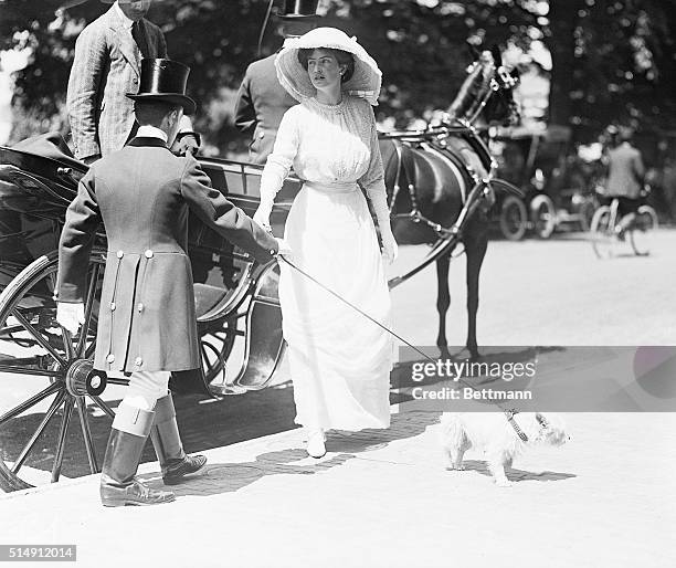 Newport, RI: Photo shows Mrs. Robert Goelet, Jr. Having stepped from a carriage, about to take the leash of her small dog from the driver.