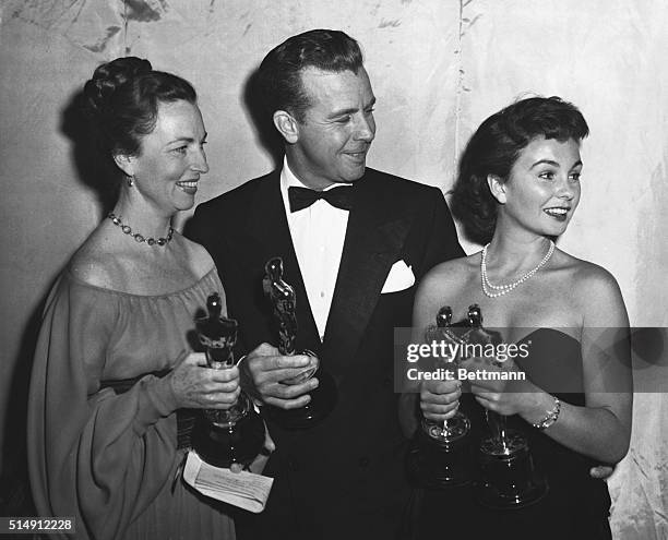 Agnes Moorehead and Dick Powell who presented Academy Awards and Jean Simmons who accepted the British Awards, pose with the Academy Awards of Motion...