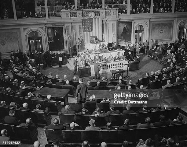 Reading Clerk Irving W. Swanson reads the Resolution for War against Germany here on December 11th, to an attentive House of Representatives. The...