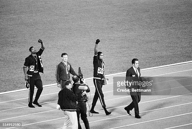 Mexico City, Mexico- Tommie Smith, center, and John Carlos, right, of the United States, raise gloved hands after receiving their Olympic Medals for...