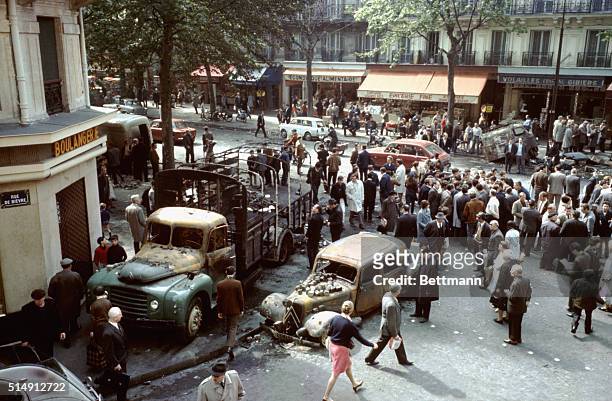 Paris, France- Passers-by and curious gather on the Meubert Square, where burned cars and trucks and road stones still remain as witness to the...