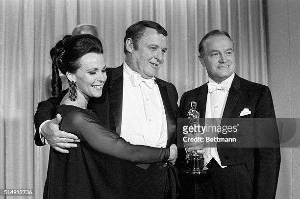 Santa Monica, CA- Hugged by his wife, Claire Bloom, and congratulated by veteran Master of Ceremony, Bob Hope, Rod Steiger is shown holding his Oscar...