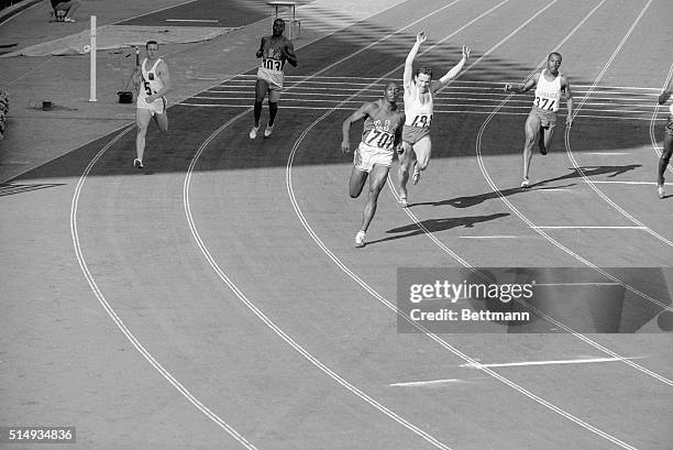 Tokyo, Japan- Bob Hayes of the United States, "the world's fastest human," streaks past Wieslaw Maniak of Poland after finishing the 100-meter dash...