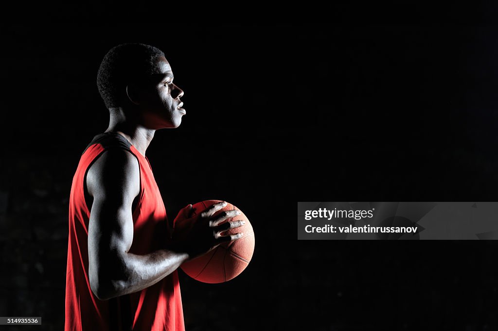 Young basketball player with a ball - side view