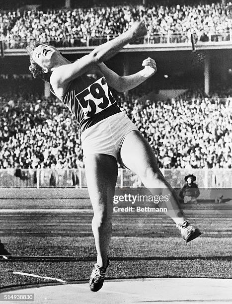 Melbourne, Australia- DISCUS DANCE--OF A CHAMP. Czechoslovakia's Olga Fikotova, with both feet off the ground, is a symphony of athletic grace and...