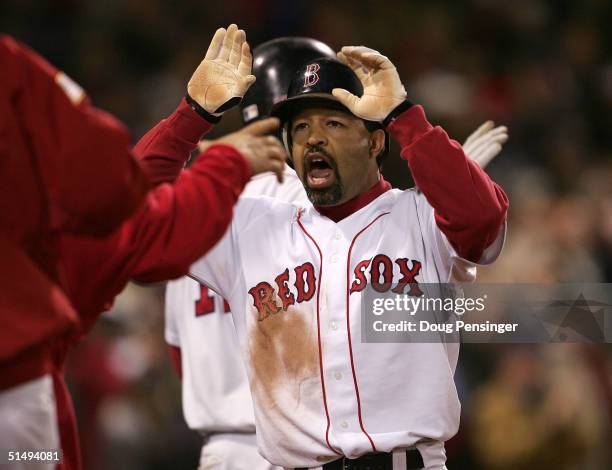 Dave Roberts of the Boston Red Sox celebrates with his teammates after scoring on a game tying sacrafice fly-out by teammate Jason Varitek in the...