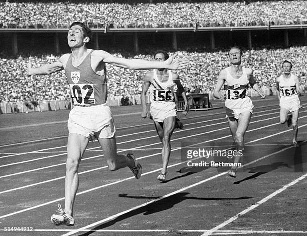 Melbourne, Australia- DELANEY WINS 1500 METERS. With outstretched arms, Ireland's Ron Delaney breasts the tape to win the final of the 1500 meters in...