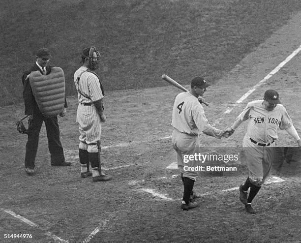 Babe Ruth is greeted at the plate by Lou Gehrig after hitting a homer in the 3rd game of the the World Series. This is the home run that was...