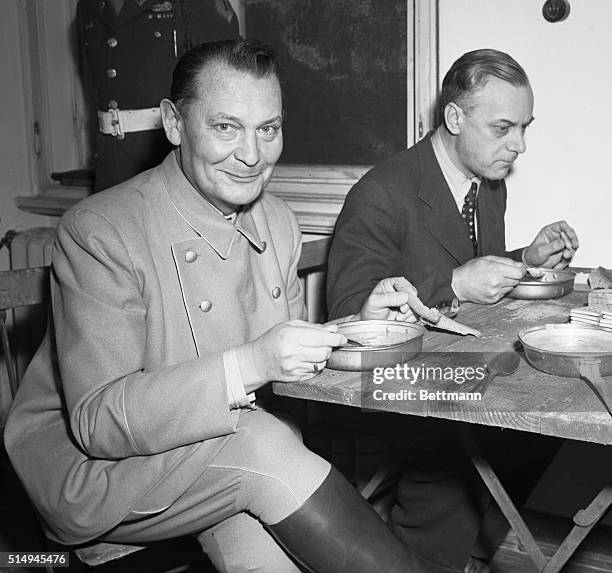 Lunch at Nuremberg Trials. Nuremberg, Germany: Smiling Hermann Goering seems to like the GI chow and doesn't seem to mind the GI silverwear as the...