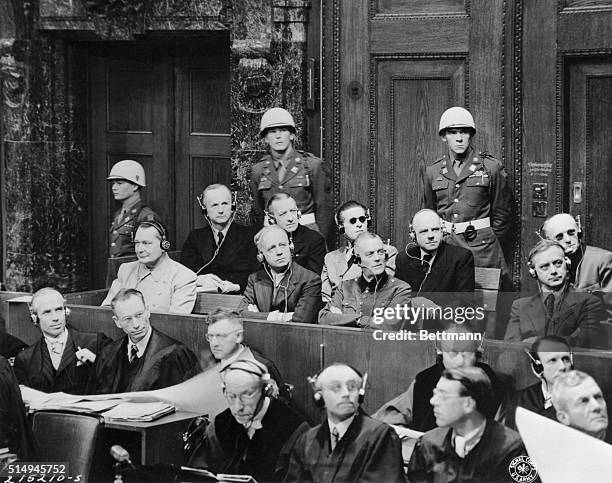 Defendants sit up and take notice at the Nuremberg war crimes trials as they stare intently at a chart of the Nazi party organization which was...