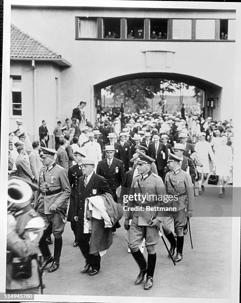 Led by Avery Brundage, head of the United States Olympic Committee, the American athletes are pictured passing through the gate into the Olympic...