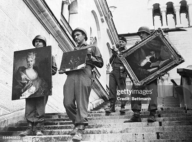 Nazi Art Loot in American Hands. Fussen, Germany: While a lieutenant checks his list , 7th Army soldiers carry three valuable paintings down the...