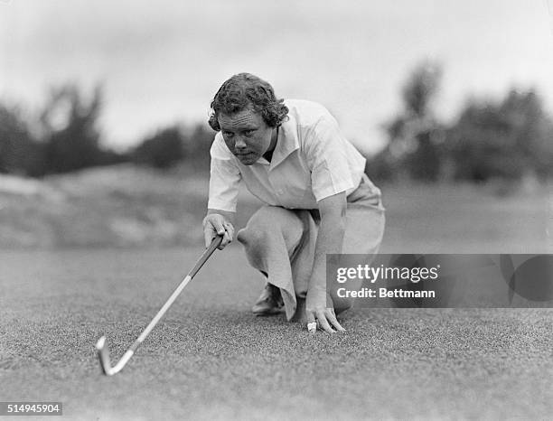 Miss Patty Berg, sensational golfer from Minneapolis, Minnesota, is shown lining up for a shot.