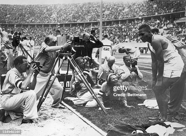 Berlin, Germany-ORIGINAL CAPTION READS: Nazi camera corps bombard a non-aryan Archie Williams, of University of California, a negro who won the...