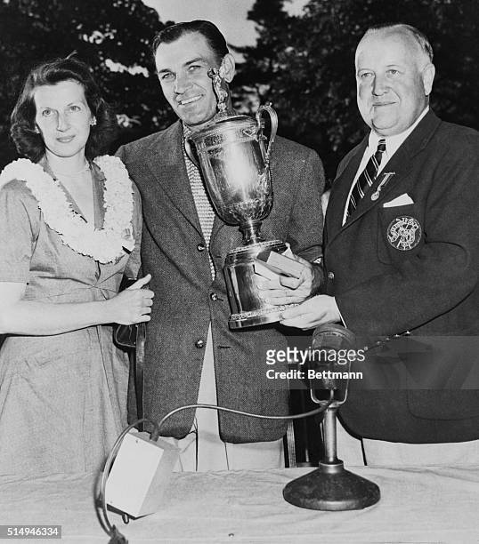 Ben Hogan , the golfing star who came back after a close brush with death in an auto accident last year, smiles as he receives trophy and prizes...