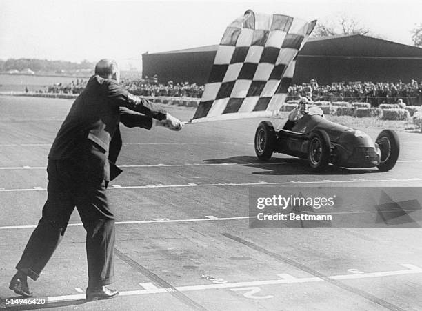 Giuseppe "Nino" Farina from Italy driving the Alfa Romeo SpA Alfa Romeo 158 takes the chequered flag to win the first World Championship Formula One...