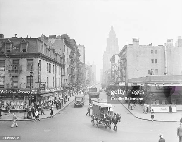 Horse-drawn wagon mixes with auto traffic in 1940s Greenwich Village.