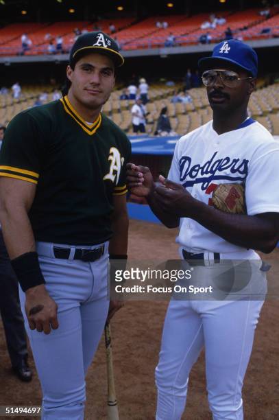 Jose Canseco of the Oakland Athletics and Mike Davis of the Los Angeles Dodgers pose together during the World Series at Dodger Stadium on October...