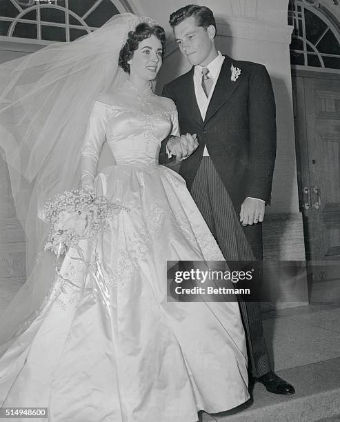 Mr. And Mrs. Conrad Nicholson Hilton, Jr., stand on the steps of the Church of the Good Shepherd after their wedding. Bride is Elizabeth Taylor of...