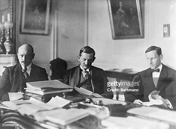 Versailles, France- Three of the chief German delegates going over important treaty documents in their council room at Versailles. The envoys are,...