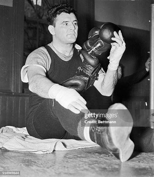 James J. Braddock, former heavyweight champion, looks over a head gear and boxing gloves at Stillman's Gymnasium, May 3, as he started conditioning...