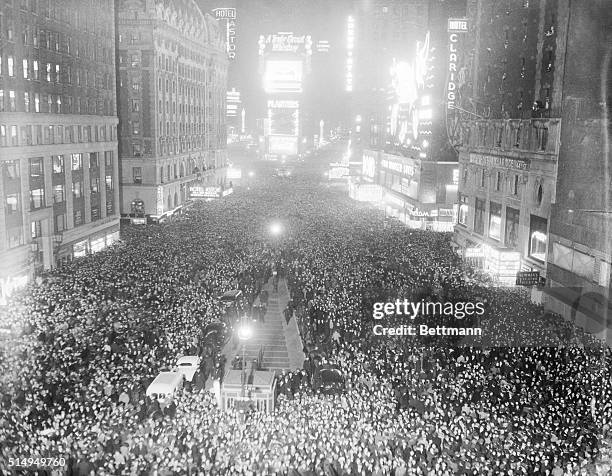 New York, New York- the usual hectic happy crowd jams Times Square to cheer in the New Year in spite of the war. This photograph was snapped just as...