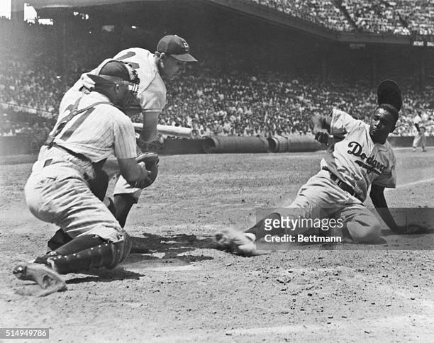 Jackie Robinson, of the Brooklyn Dodgers, slides home on a steal in the fourth inning of the first game of a double header with the Phillies July 2....