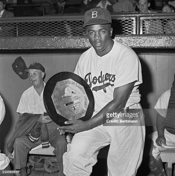 Jackie Robinson, second baseman of the Dodgers, holds the gold plaque, symbolic of the Most Valuable Player Award he won in 1949, which was presented...