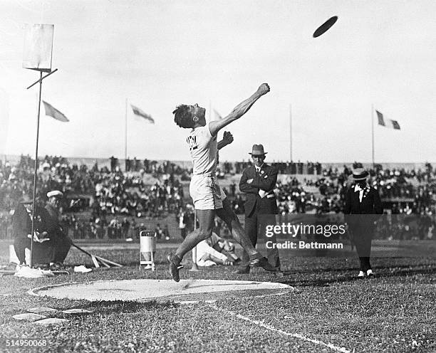 Paris, France- Bud Houser of California, a member of the American Olympic Team, is shown heaving the discus for a new record at the Olympic games....