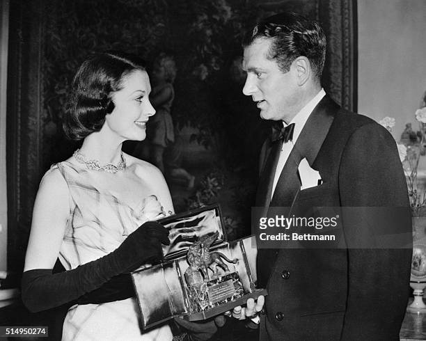 London: Family Award. Actress Vivien Leigh and actor husband Laurence Olivier admire a trophy received at a reception held at the Italian Embassy in...