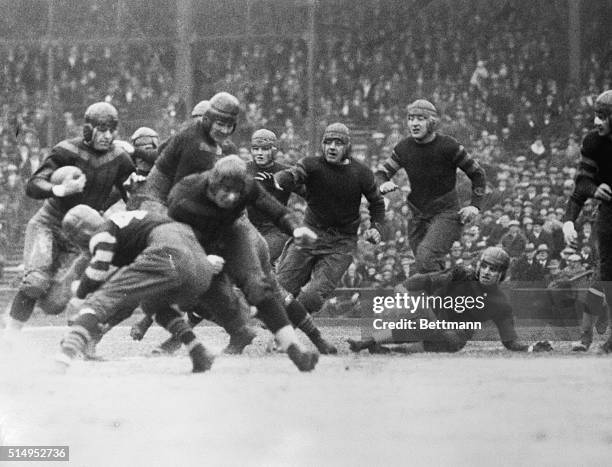 Red Grange at left trying to get through the Chicago Cardinals line in the game between the Chicago Bears and the Cardinals in Chicago when Grange...