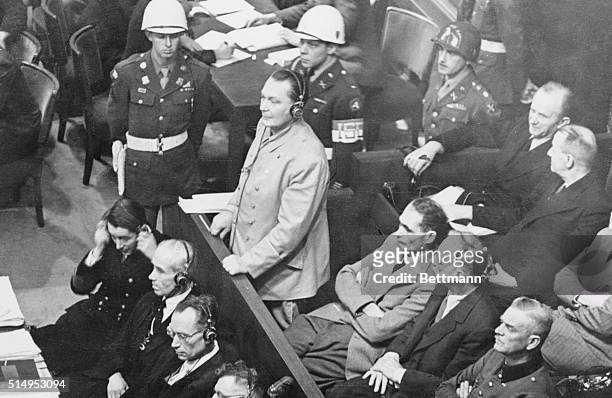 Fatso Cops A Plea. Nuremberg, Germany: Hermann Goering, Nazi Reichsmarshal, rises in the prisoner's dock to plead not guilty during the second day's...