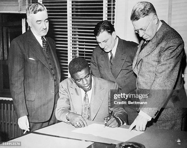 Jack Roosevelt Robinson, the first Negro to win a contract in organized baseball, is shown signing for the Montreal Royals of the International...