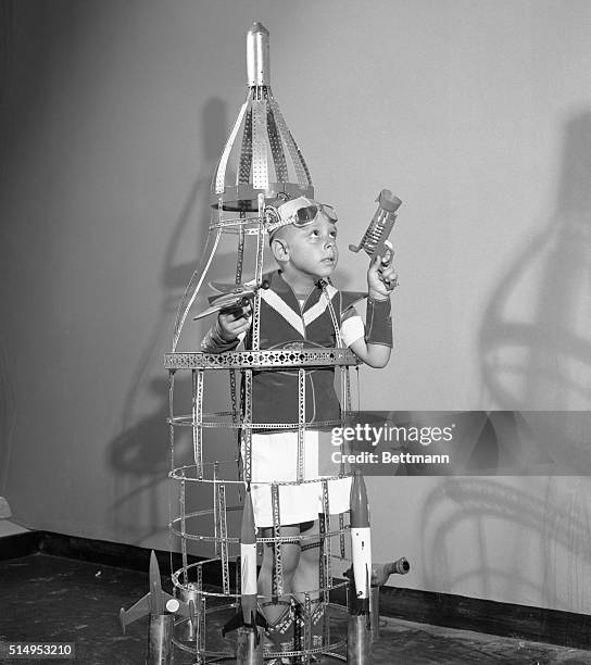 New York, NY: Six year old Johnny Schloss, a daring space traveler from Brooklyn, tries out this unusual rocket ship, built from erector set parts....