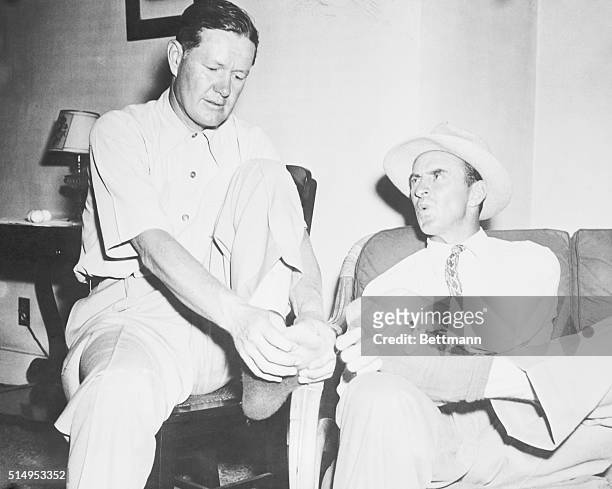 Golfers Byron Nelson and Sam Snead , tied at 144 even par at the end of the first 36 holes of the 72 hole War Bond match, ease their burning feet in...