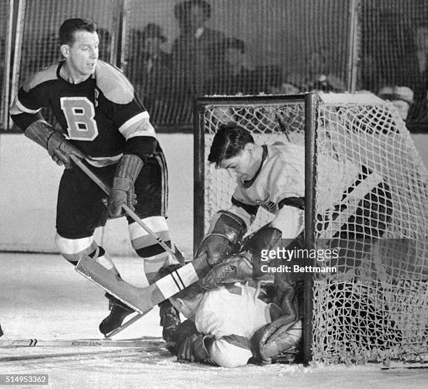 It's a crowded cage as Marcel Pronovost, of the Detroit Red Wings slides under teammate goalie Terry Sawchuck to provide a combined effort to block...