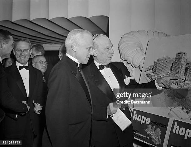 Alfred P. Sloan, Jr., is shown pointing to a picture of the new building to Dr. Karl T Compton, President of MIT, at the dinner held at the Biltmore...