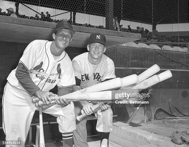 New York Yankee batting star Mickey Mantle takes a good look at the bat held by Cardinal slugger Stan Musial, march 7, at St Petersburg, Floroda,...