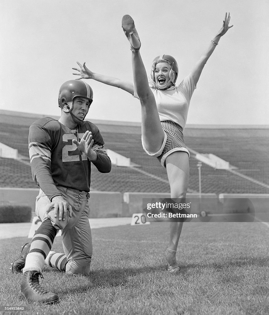 Mamie Van Doren Kicking on Football Field with Jim Sears