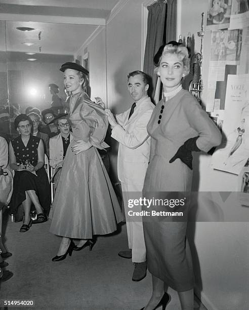 Fashion designer Charles James stands with two of his models during a fashion show.