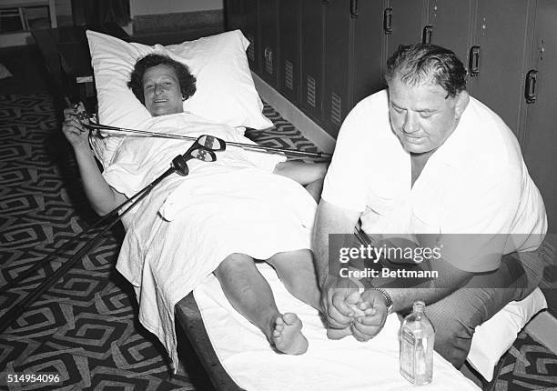 Relaxing luxuriously in the locker room, Babe Zaharias enjoys husband George's attentions to her tired toes as she makes her tournament comeback at...