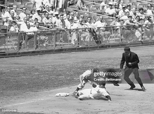 Yankee catcher Yogi Berra safely slides into third base after blasting a triple against the St. Louis Browns in the second inning of their game at...