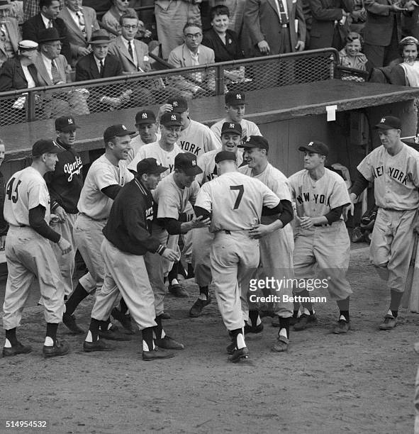 Outfielder Mickey Mantle is mobbed by Yankee teammates after crossing the plate with his grand-slam homer in the third inning of the fifth 1953 World...