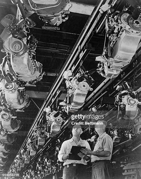 Engine stocks, stored on overhead conveyors at the Studebaker plant in South Bend, are looked over by checkers as they await their turn on the...
