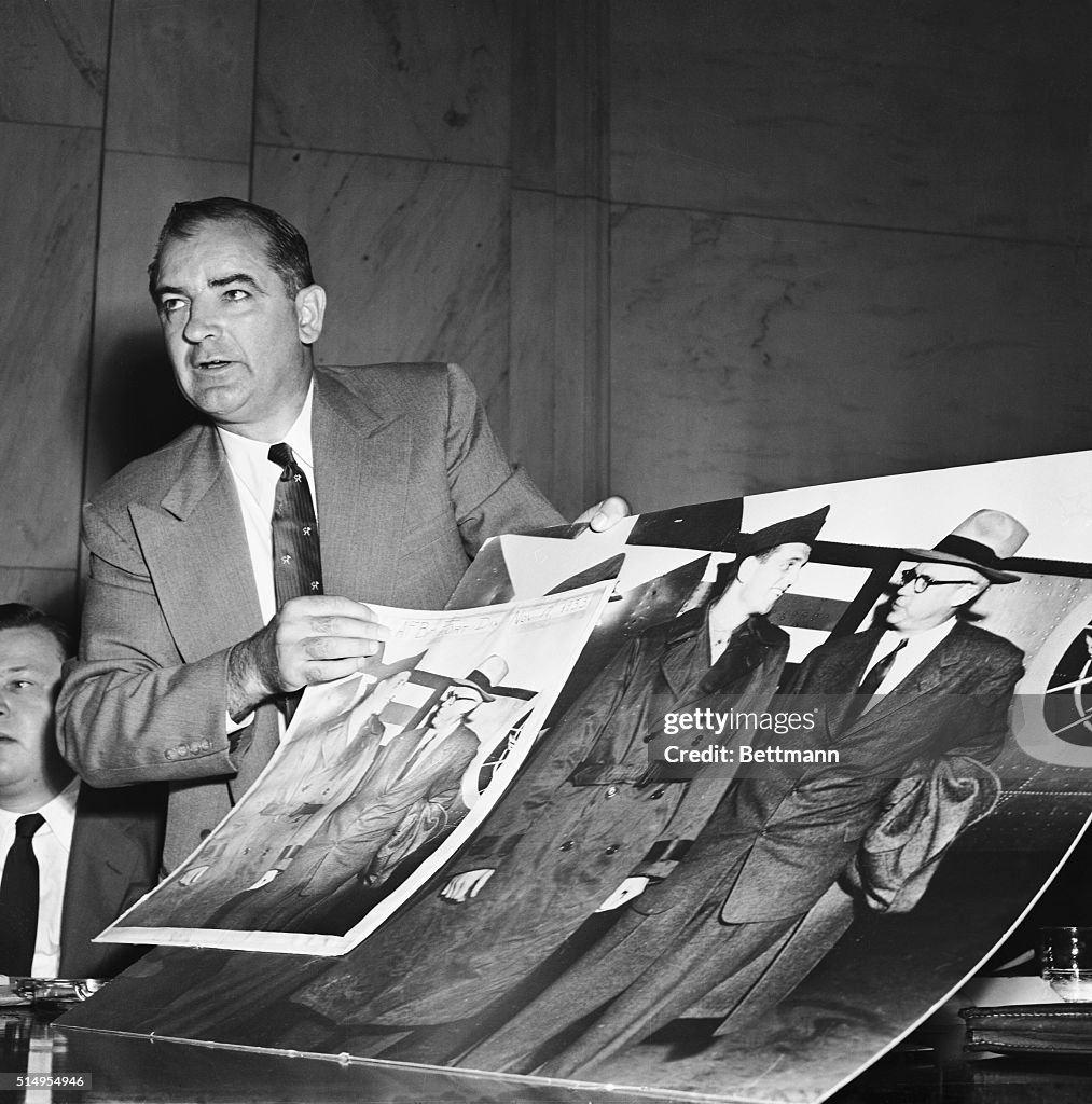 Joseph McCarthy Holding Large Photographs