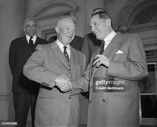 President Eisenhower and Gen. Douglas MacArthur shake hands after posing for photographers on the White House North Portico. The Generals joined the...