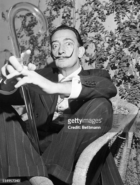 Holding his famous glass walking stick, surrealist painter Salvador Dali meets newsmen at his Rome hotel. He is in the Eternal City in connection...